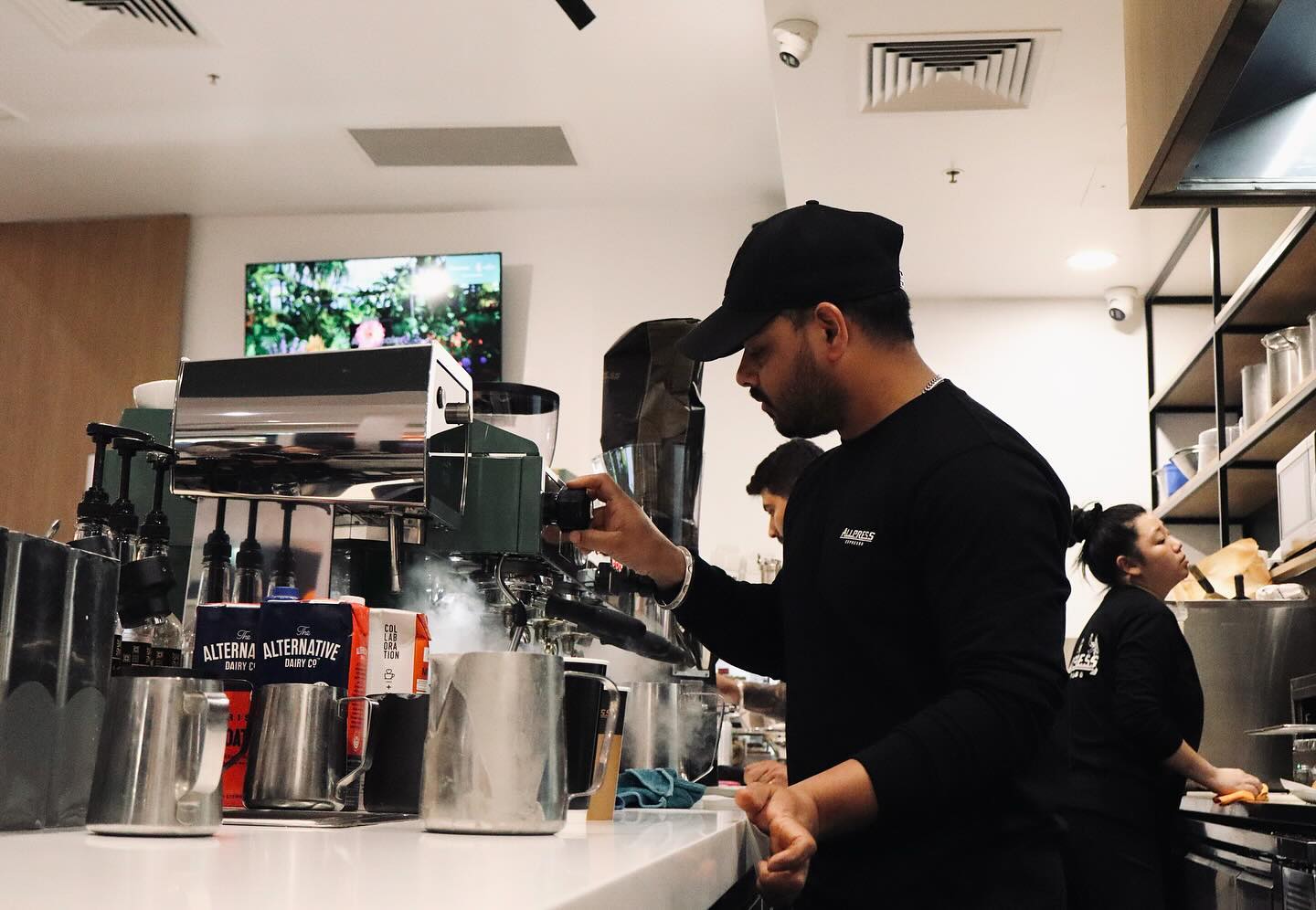 A barista preparing coffee on a polished espresso machine